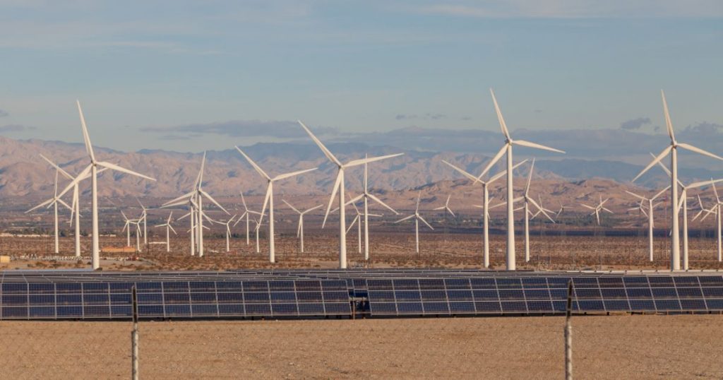 Solar panels and wind turbines by the mountains